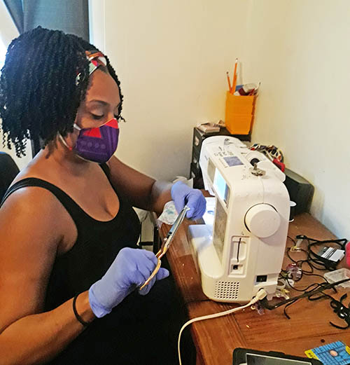 Jeanelle Hampton works on a mask. She said after posting an example of her work online she was inundated with requests for masks. (Provided photo)