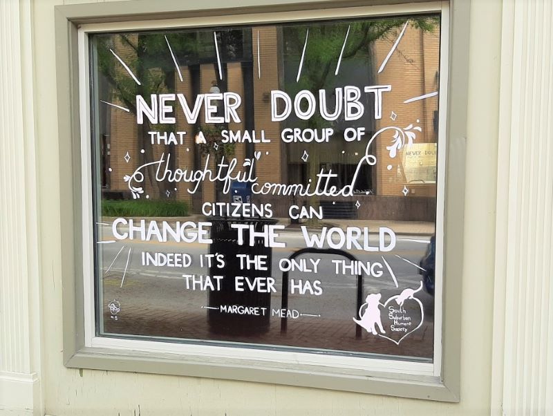 Homewood Art Council sponsored a project to paint inspirational quotes, such as this one by anthropologist Margaret Mead, on storefront windows in the downtown area. (Photo by Timothy Dudik)