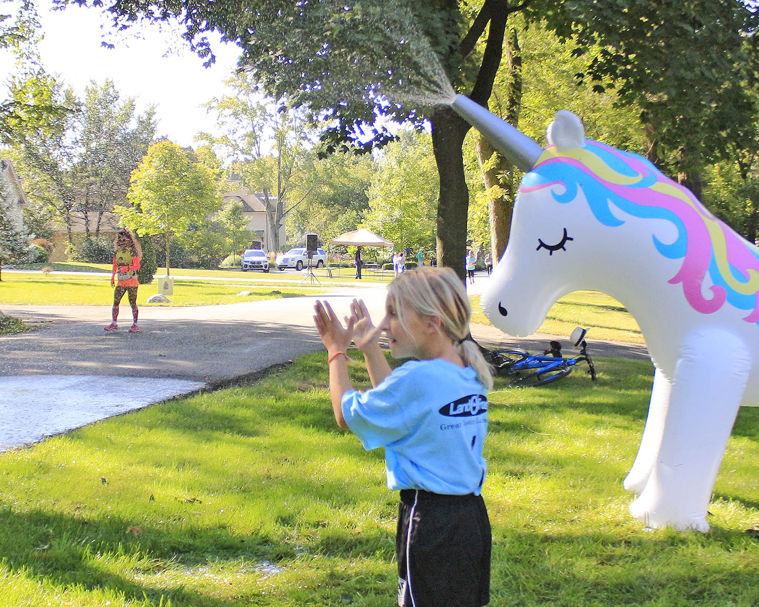 Georgia Bruni claps as runners pass her home during the 2019 Hidden Gem Half Marathon. She and her mom, Jeanette Bruni, set up a unicorn water spray to cool off runners. (Chronicle file photo)
