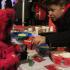 Cynthia Rivera, 6, of Matteson, gets help making reindeer food from Michele Kossak, a volunter at the St. Joseph Youth Group table.