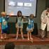 Testing a theory about magnetism presented by magician and Governor State University chemistry professor John Sowa, right, children, from left Ezra Raferty, Kayleigh Russell and Claire Kelsven drop magnets and a feather to see which is heavier.